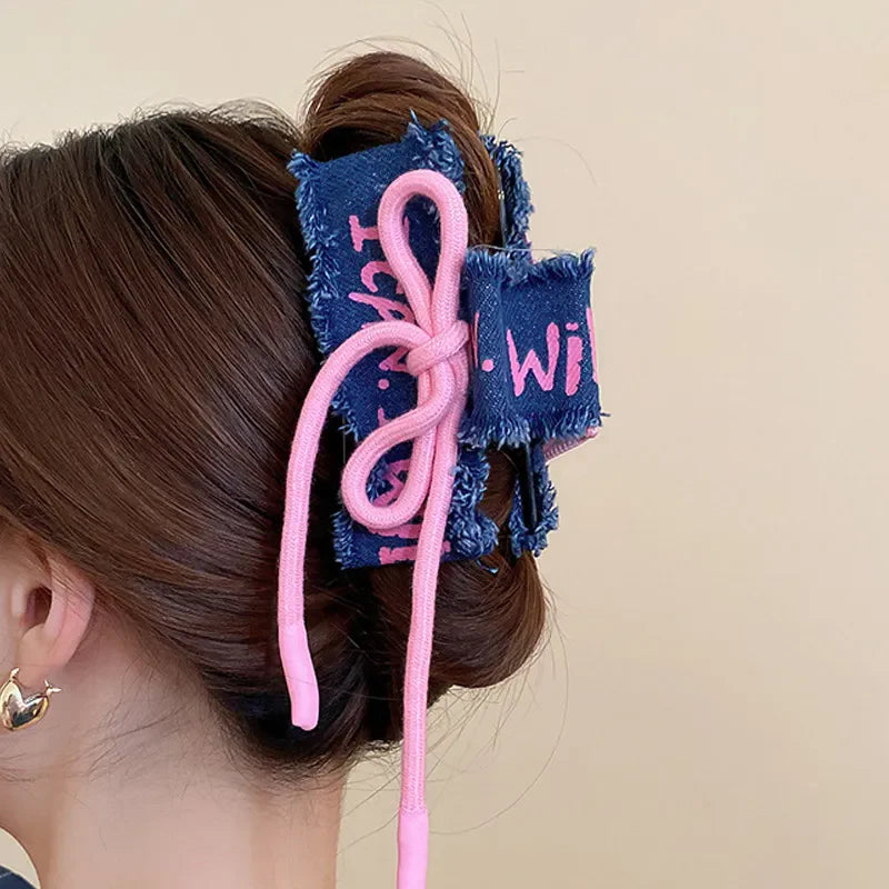 Denim patchwork claw clip with pink drawcord detail.