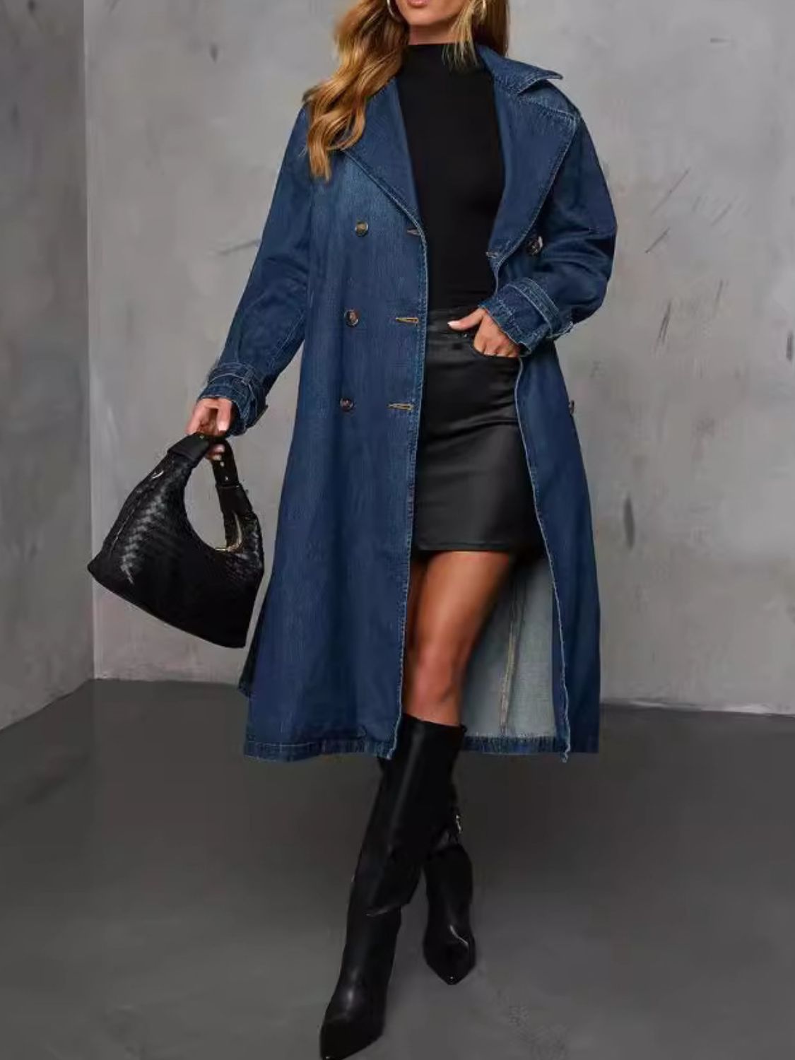 Denim trench coat in dark blue with belted waist, double-breasted buttons, and classic collar.