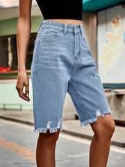 Light blue denim knee-length shorts with distressed details and frayed hem