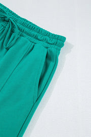 Turquoise relaxed fit lounge pants with drawstring waist and cargo pockets.