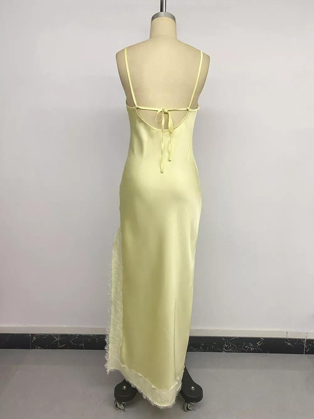 Yellow lace-trimmed midi slip dress with side slit and tie back.
