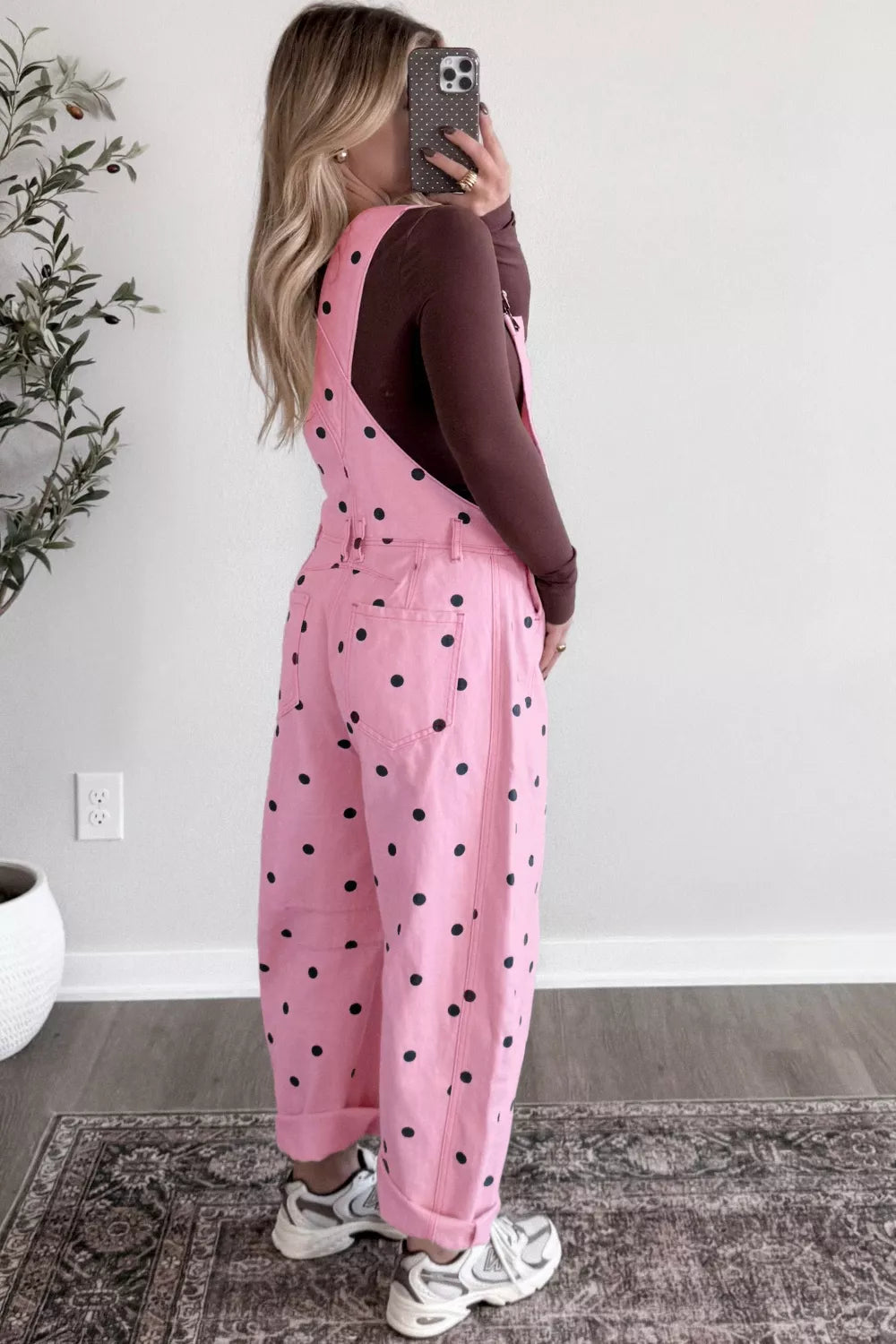 Pink polka dot denim overalls with bib pocket and barrel leg cut.
