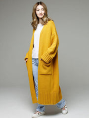 Oversized gold ribbed-trim maxi cardigan with pockets, styled casually with jeans.