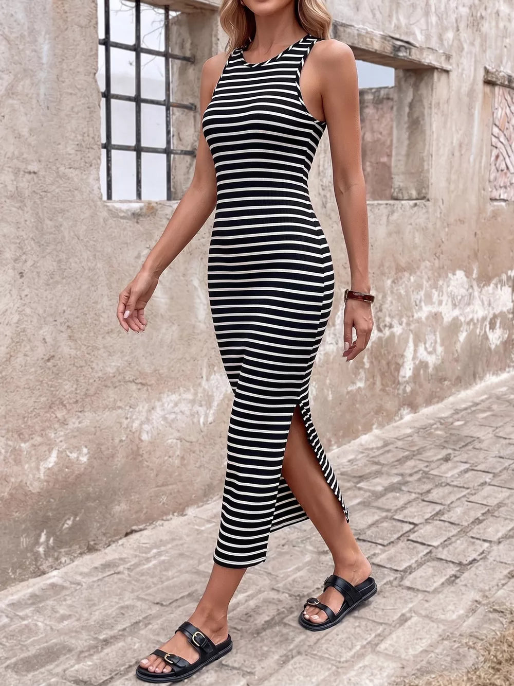 Chic black and white striped midi dress with a side slit and sleeveless design.