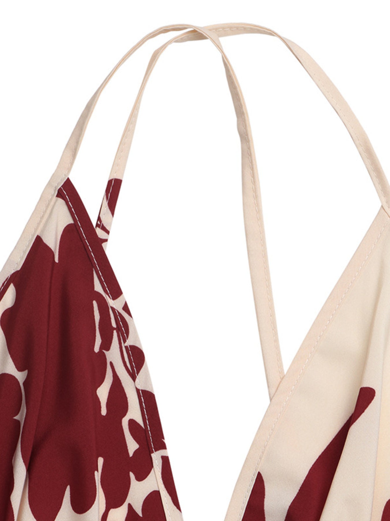 Maxi dress with deep V-neck, spaghetti straps, and a bold floral print in maroon and cream.