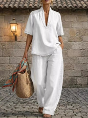 White cotton V-neck top and wide-leg pants set with cuffed ankles and curved hem