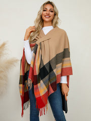 Asymmetric plaid fringe cape in tan with red, black, and yellow checkered pattern.