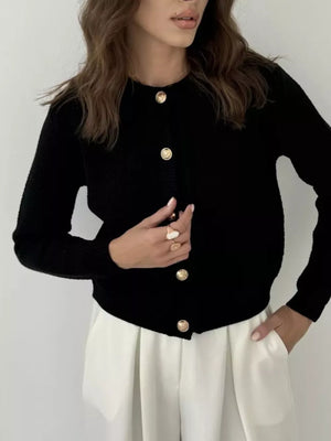 Black textured knit cardigan with elegant gold button detail and crew neck.
