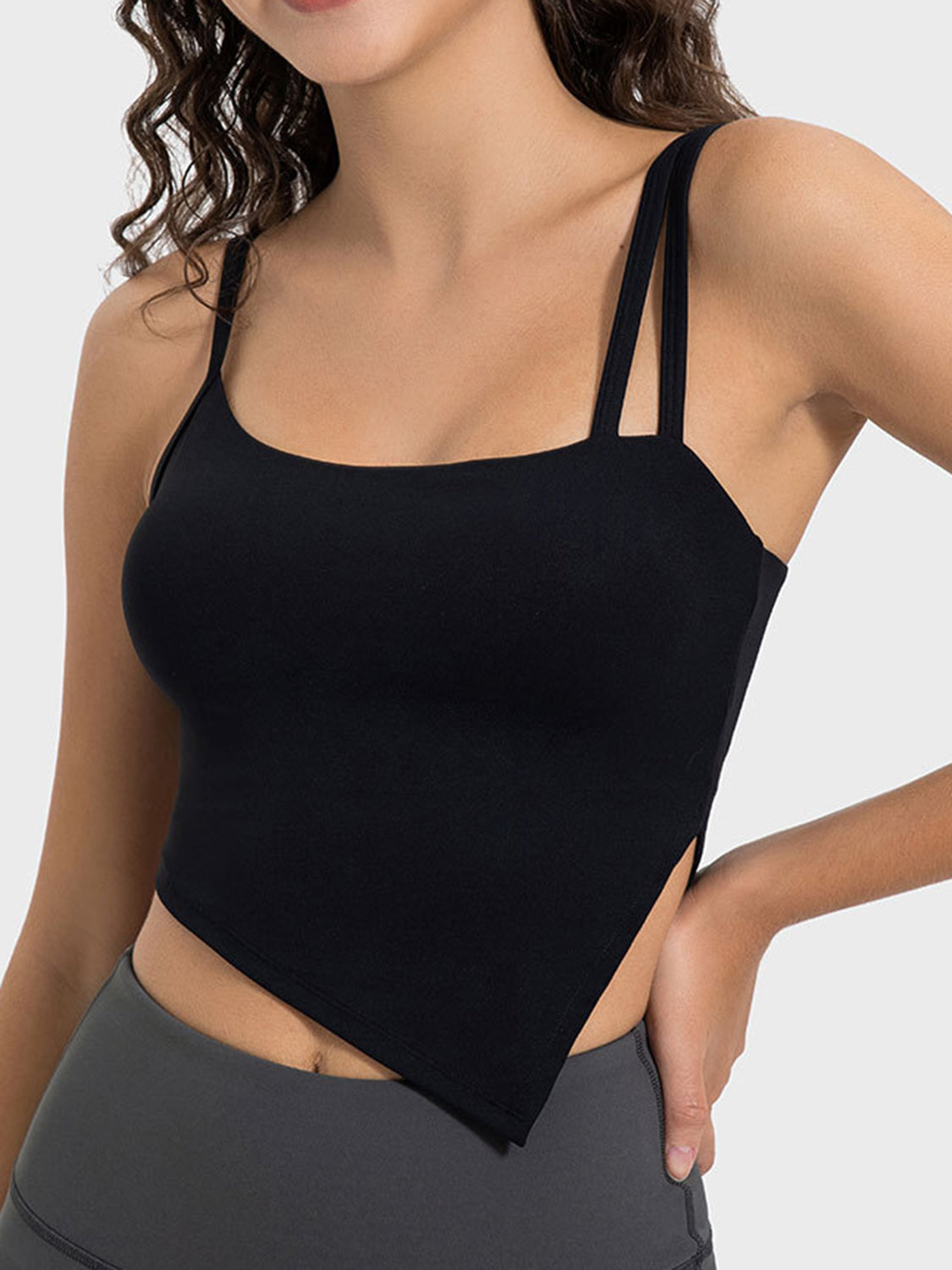 Black asymmetric cutout cami top with double spaghetti straps and a handkerchief hem.