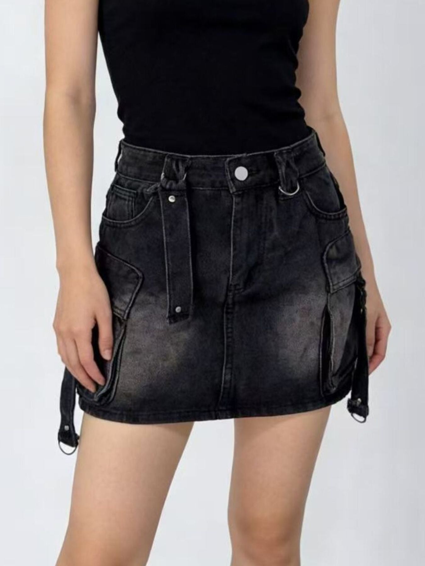 Black washed denim cargo skirt with button closure and adjustable straps.