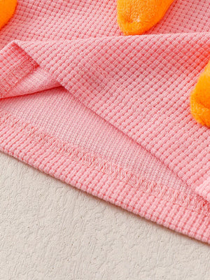 Pink waffle knit baby set with 3D carrot appliqués.