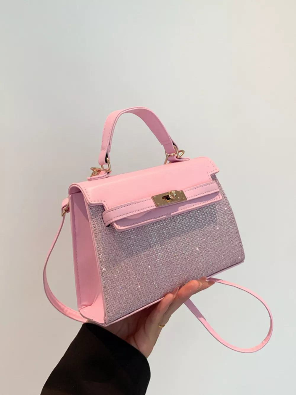 Pink glitter textured mini crossbody bag with gold hardware and top handle.