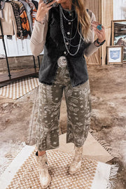 Black button-front denim vest with silver buttons and a distressed hem, styled with layered necklaces.