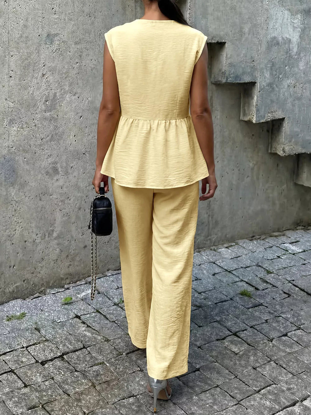 Yellow peplum hem two-piece set with button detail, cap sleeves, and wide-leg pants.