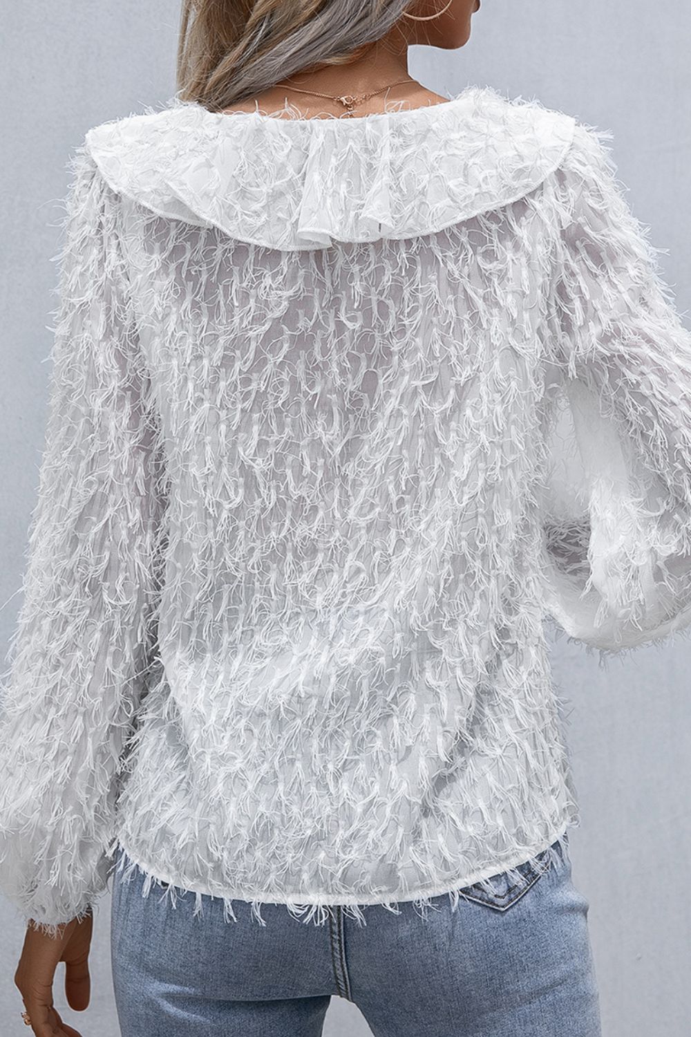White textured ruffle front blouse with balloon sleeves and fringe detail