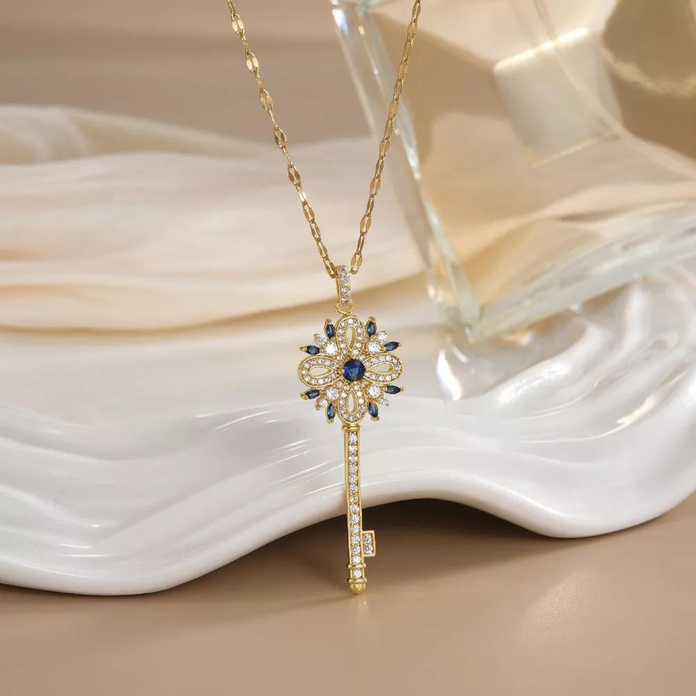 Gold-plated key pendant necklace with blue and white crystals, delicate design