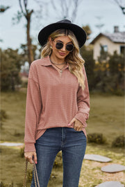 Textured cable knit polo top in dusty pink with a V-neck and long sleeves.