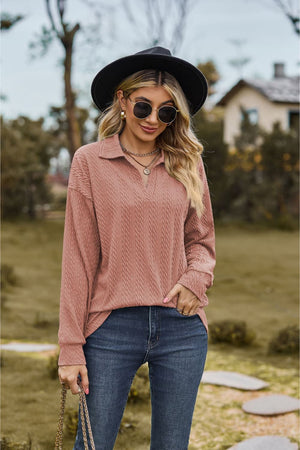 Textured cable knit polo top in dusty pink with a V-neck and long sleeves.
