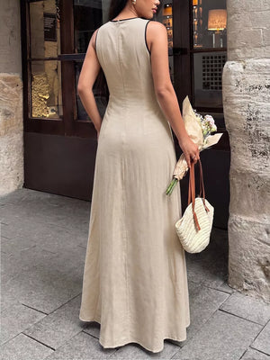 Elegant beige maxi dress with black piping details and a flowing skirt.