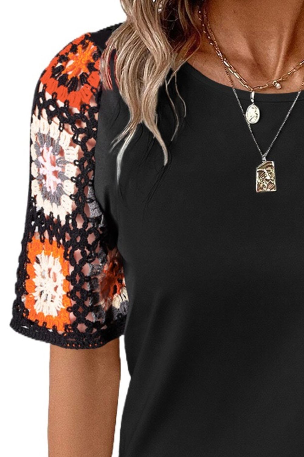 Black t-shirt with colorful granny square crochet sleeves.