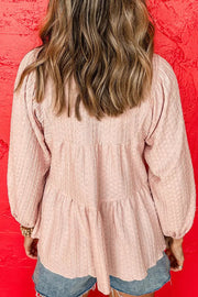 Textured tiered blouse in watermelon pink with balloon sleeves and tie detail.