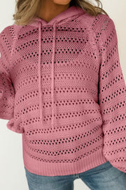 Dusty pink openwork knit hoodie with drawstring and cotton blend material.