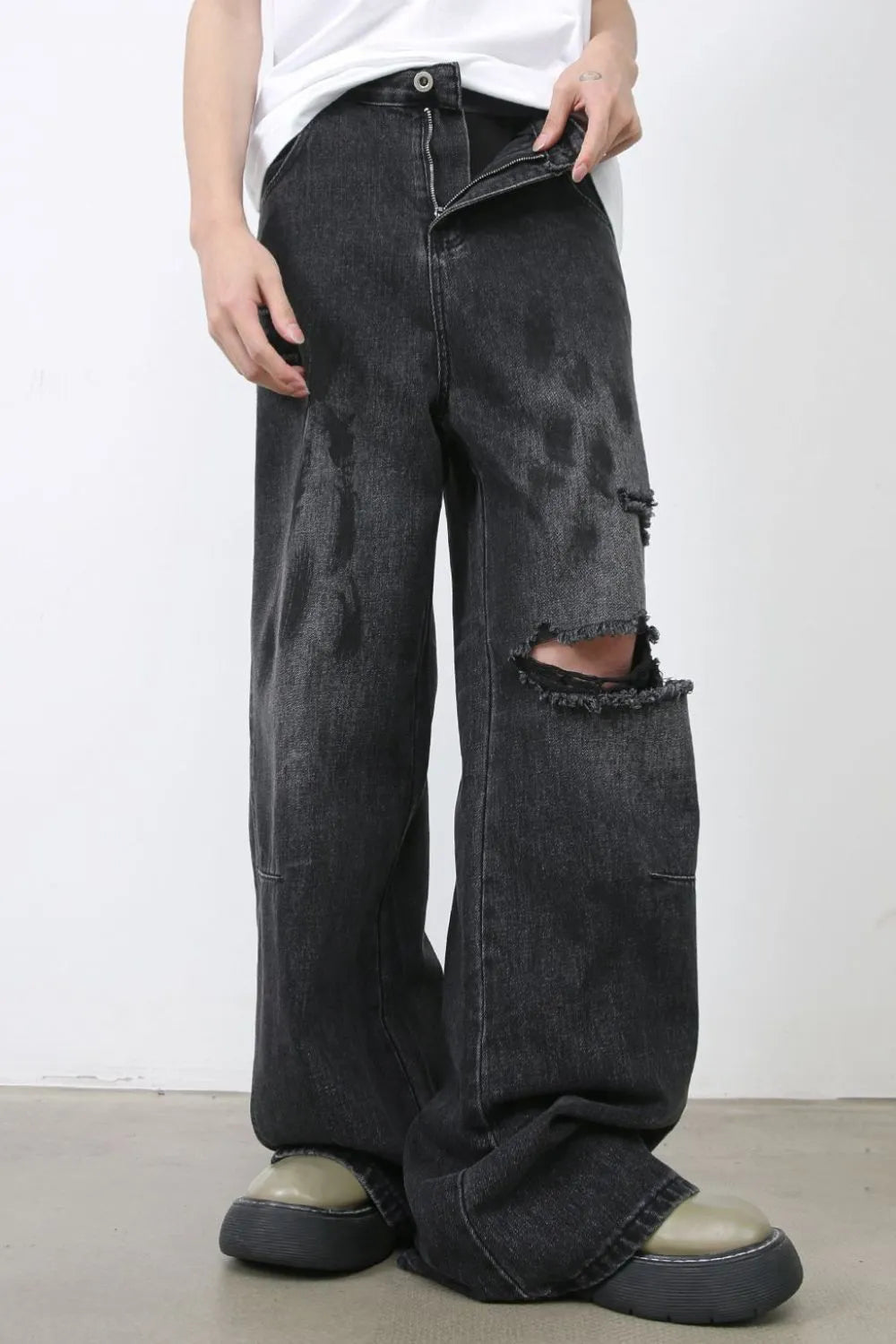 Rugged relaxed fit dark wash denim jeans with distressed knee rips.