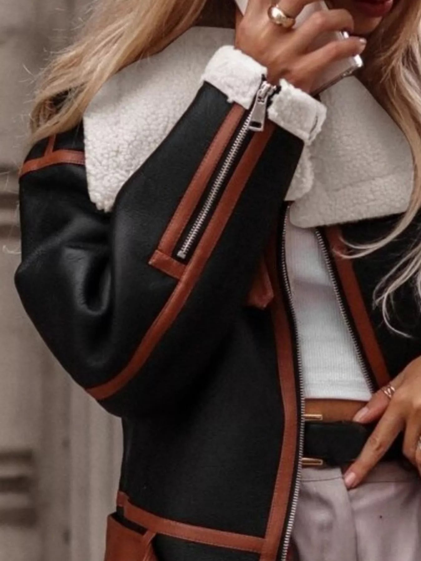 Black shearling lined zip up jacket with brown trim and white collar detail