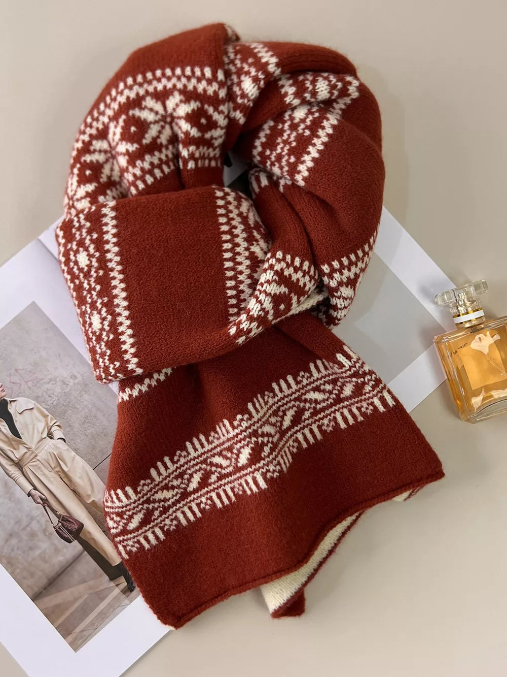 Reversible wool blend scarf in orange red with white snowflake pattern.