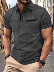 Dark gray textured polo shirt with contrast pocket detail and short sleeves.