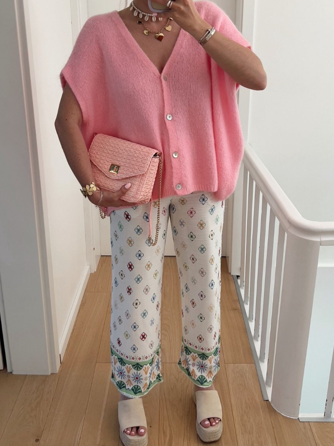 Pink mohair cap sleeve cardigan with pearl buttons, styled with patterned pants and a pink woven crossbody bag.