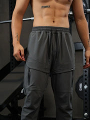 Gray technical joggers with zip pockets and drawstring waist.