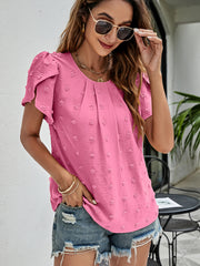Pink textured puff sleeve blouse with dot pattern and round neckline.