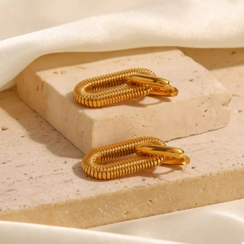 Gold sculptural link drop earrings with ribbed texture and polished finish.