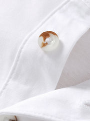White cotton polo shirt with button detail and chest pocket.