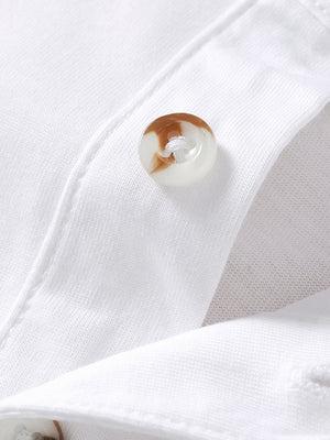 White cotton polo shirt with button detail and chest pocket.