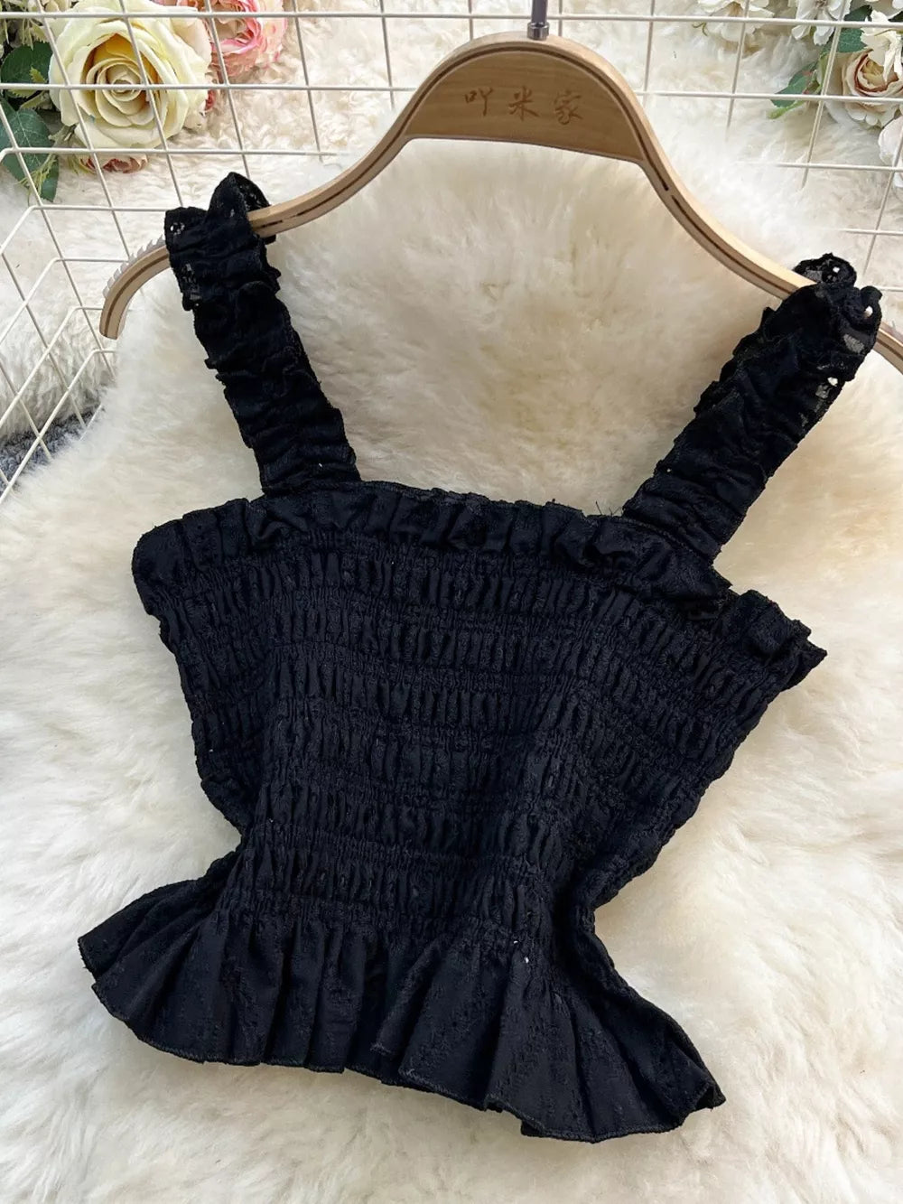 Black ruffled crop top with eyelet detail and smocked bodice