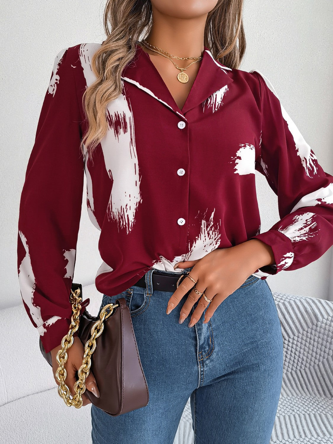 Burgundy brushstroke print collared blouse with white abstract strokes, button front, and long sleeves.