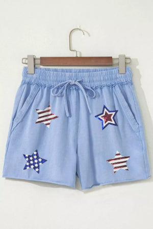 Light blue cotton chino shorts with drawstring and sequined stars pattern.