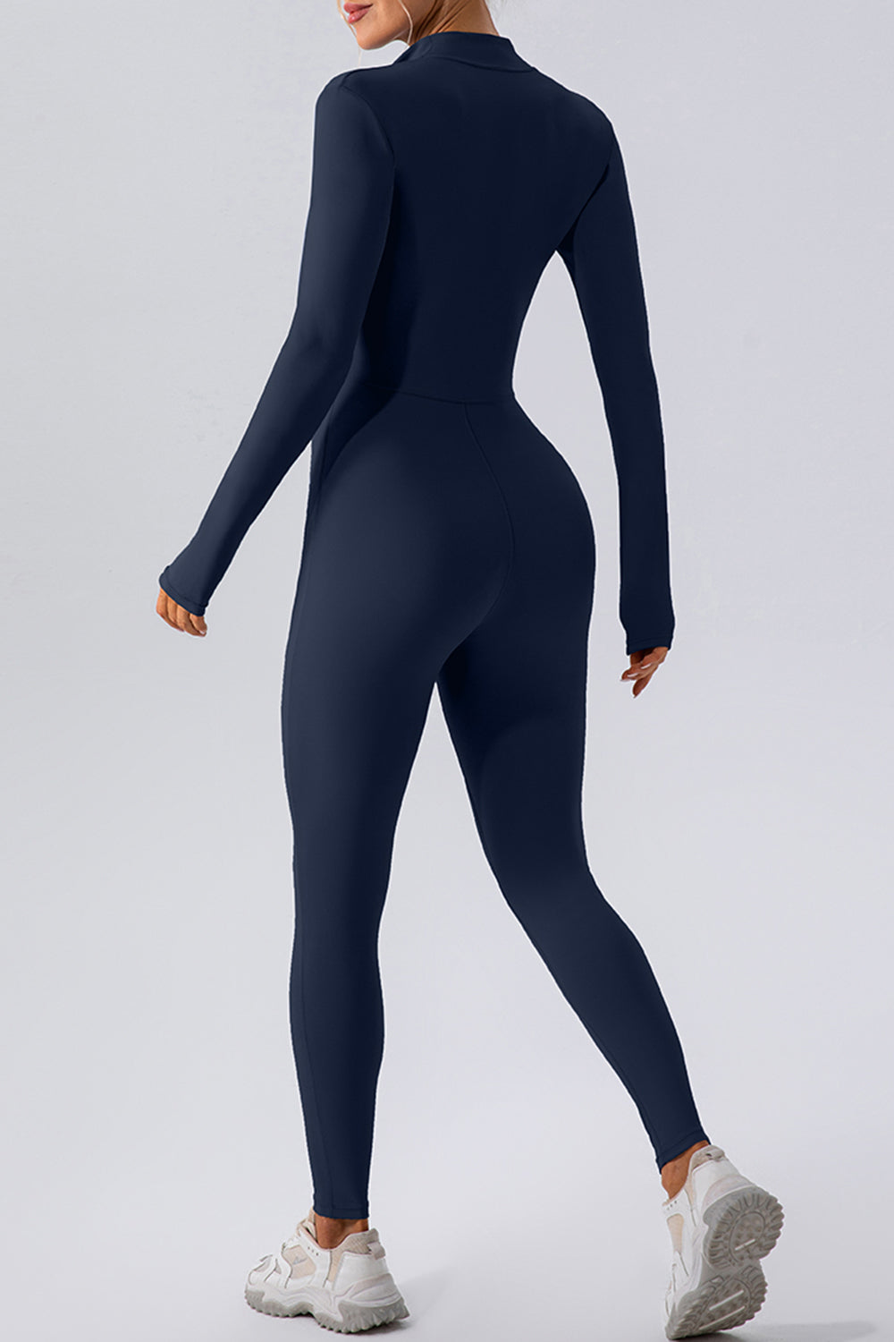 Dark blue zip-front bodycon jumpsuit with long sleeves and a high neckline.