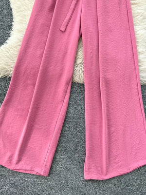 Belted wide-leg jumpsuit in pink cotton with a tie waist detail.