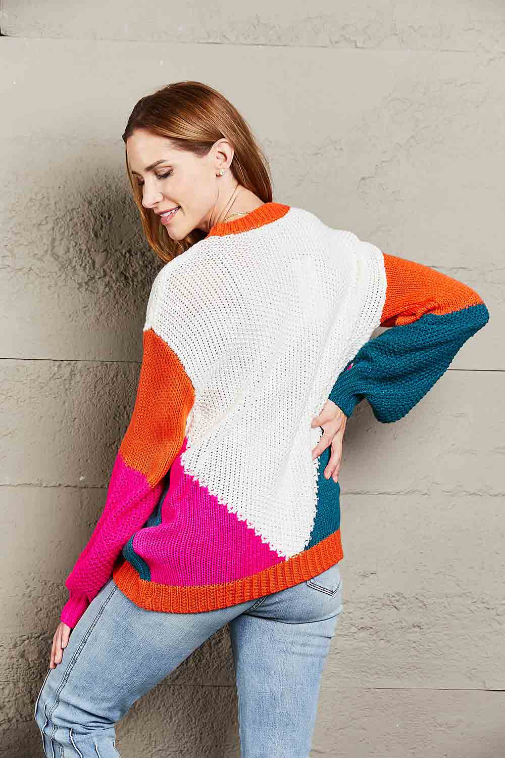 Colorblock knit sweater with sculpted sleeves in white, orange, pink, and teal acrylic.