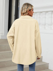 Oversized corduroy shirt jacket in cream with buttoned cuffs and a relaxed fit.