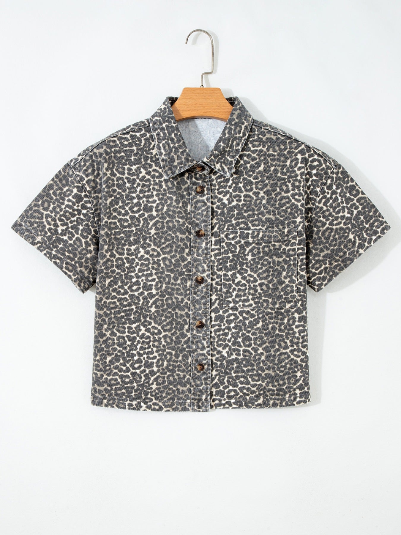 Leopard print denim short-sleeve shirt with button front and chest pocket.