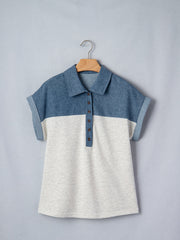 Two-tone denim polo shirt with button placket and rolled sleeves.