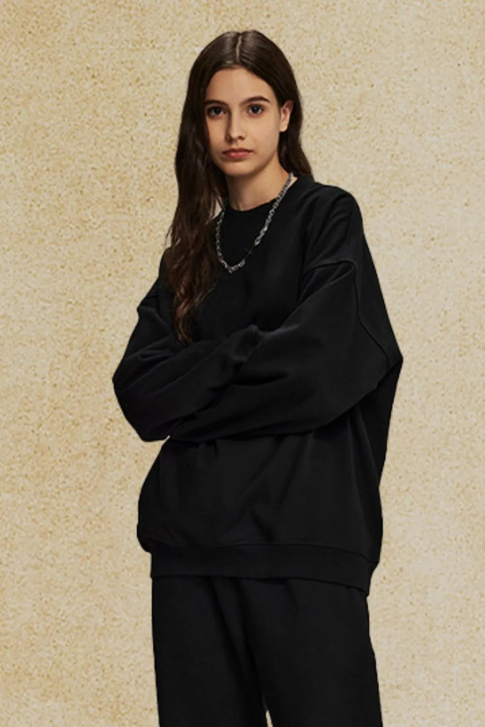 Black oversized crewneck sweatshirt with subtle shoulders and a relaxed fit.