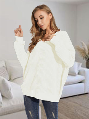 Relaxed fit ivory ribbed knit sweater with V-neck and batwing sleeves.