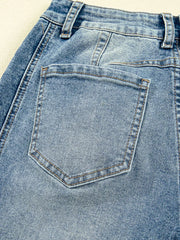 Light wash denim maternity jeans with classic back pocket detail and visible seams.