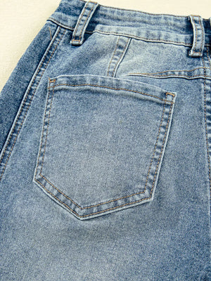 Light wash denim maternity jeans with classic back pocket detail and visible seams.