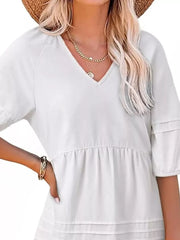 White denim mini dress with puff sleeves, V-neck, and tiered skirt.